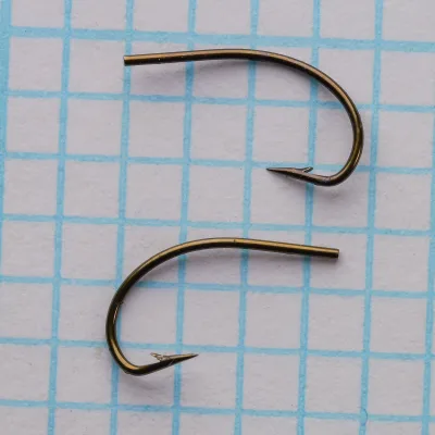 Partridge K4A Grub Hook size 14 — two specimens shown side-by-side on measurement grid — curved shank and tapered blind eye visible — bronzed finish