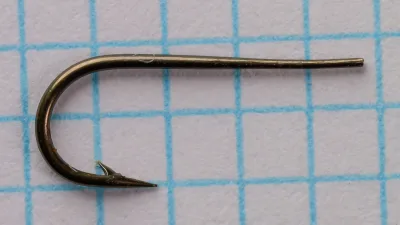 Partridge Round Taper Size 11 — side profile showing tapered blind eye and Sproat bend — bronzed finish on measurement grid