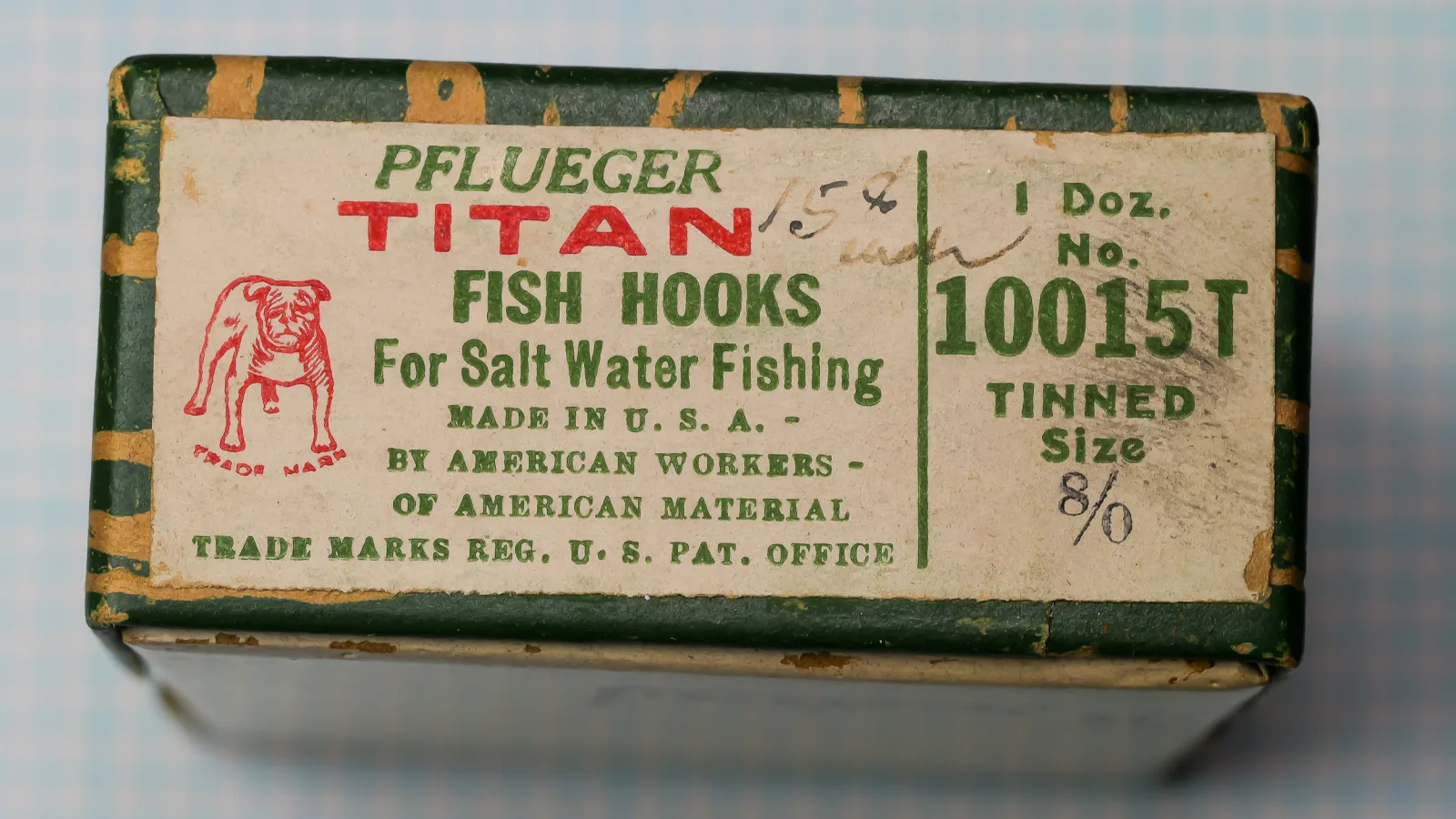 Pflueger Titan 10015T — original cloth-covered box with tan letterpress label showing red and green printing — size 8/0 — hand-forged American saltwater hook box from c. 1920-1945