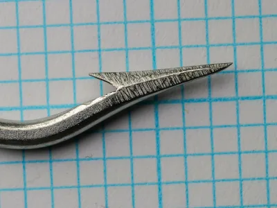 Pflueger Titan 10015T — knife-edge point and barb detail showing concave inner face — size 8/0 — forged hollow point geometry