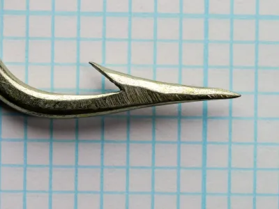 Pflueger O'Shaughnessy 15521-T — detail of hook point showing filed point geometry and slight barb angle — size 9/0 — tinned finish