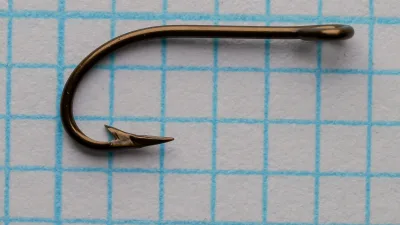 Pflueger Sproat 3521-Br No. 10 — full side-profile view of the hook showing overall proportions, parabolic bend curve, shank length, straight-ring eye, and superior point geometry