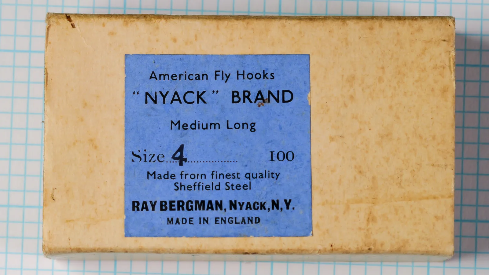 Raybergman Nyack Brand Medium Long Hook box with blue label showing text and product specifications, size 4, on measurement grid