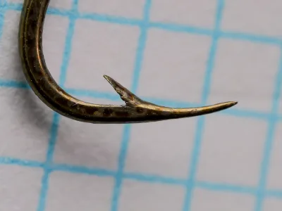 Edgar Sealey S 4310 LS Octopus Hook size 7 — close-up of point and barb — hollow point inner taper visible — forged wire profile — bronzed finish