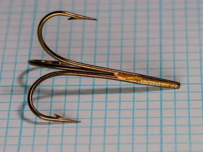 Mustad 3601 B Treble Size 2 — side profile showing rounded Sproat bend, parallel shank, and hollow-point taper — bronzed finish