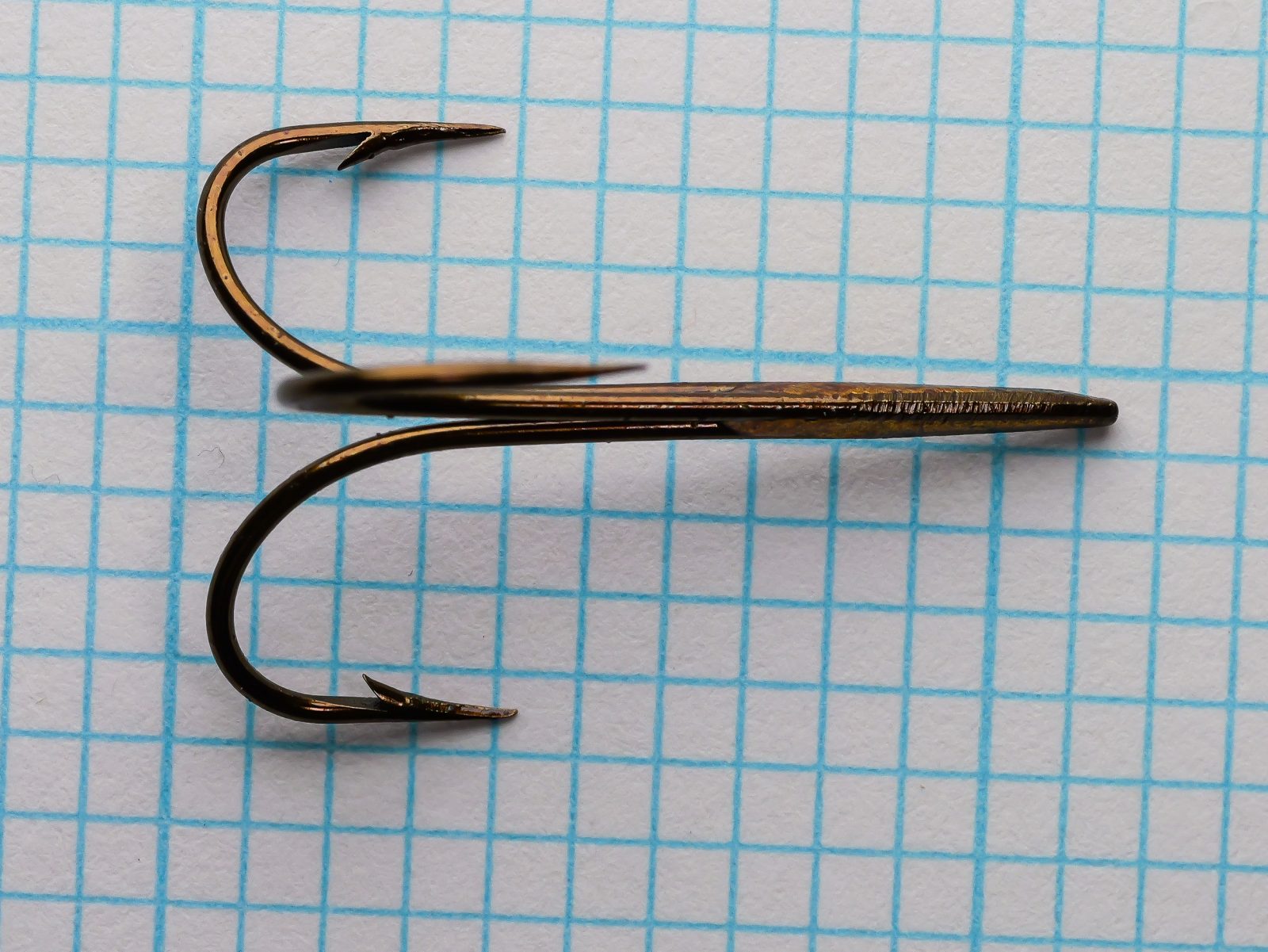 Mustad 3601 B Treble Size 2 — overhead view showing three-point symmetric configuration, parallel shank positioning, and barb geometry