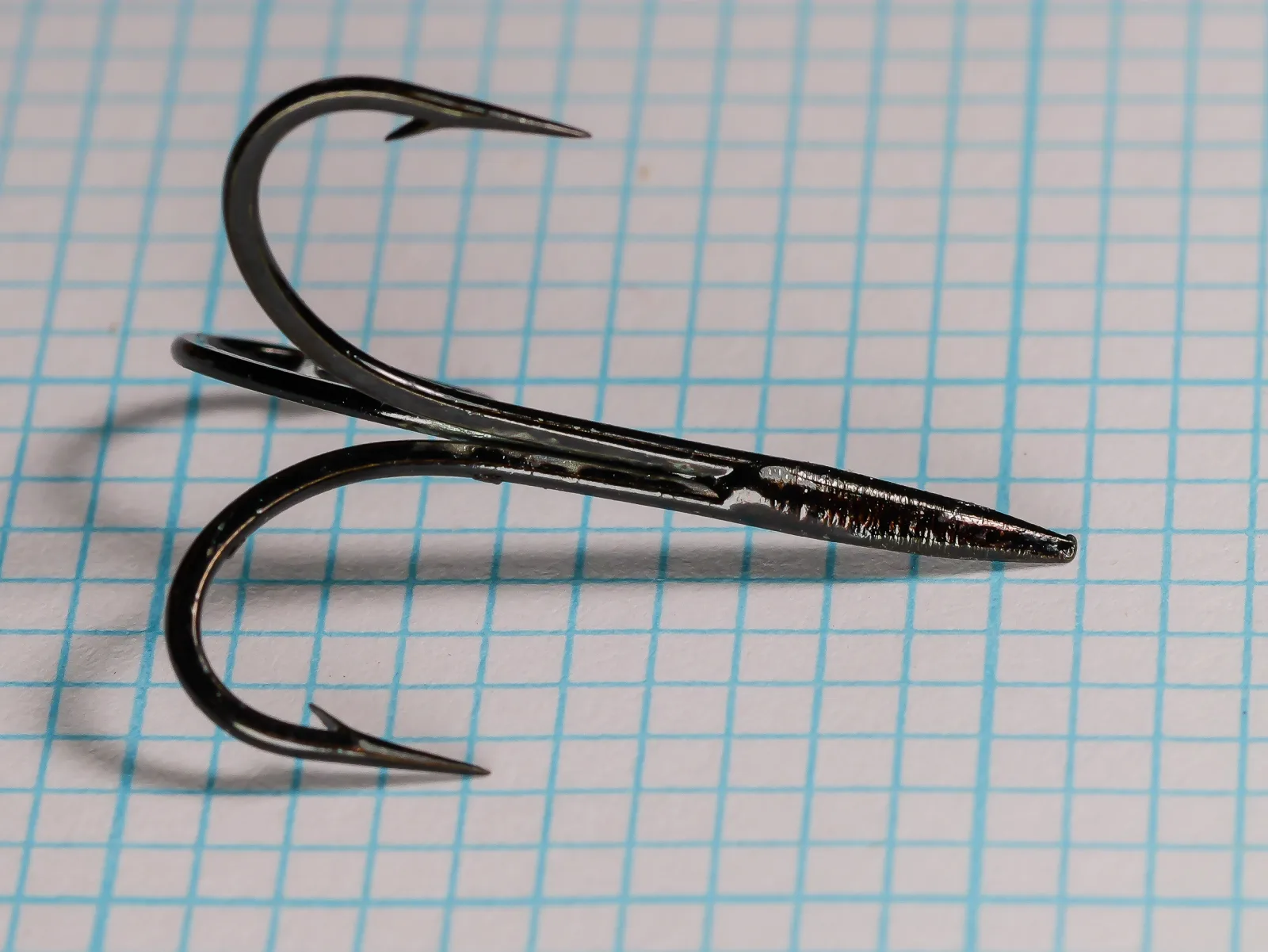 Mustad 3621 Blind Eye Treble — side profile view showing O'Shaughnessy bend curve and tapered shank — size 2 — black japanned finish on measurement grid