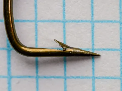 Partridge D.E. Sneck size 4 hook point detail — closeup showing Sneck bend geometry, barb placement, and point taper — bronzed finish