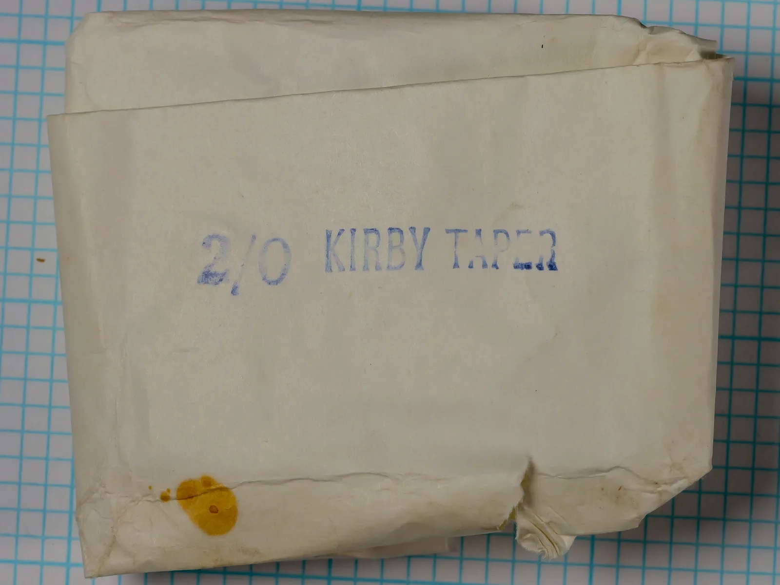 Partridge Kirby Tapered 2/0 — tissue envelope packaging front — hand-stamped blue label — vintage cream paper with age toning
