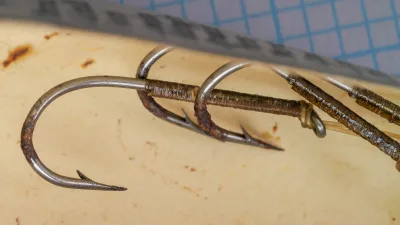 S. Allcock 4555B Cinning Bass Hook Size No. 24 — close-up front face showing point geometry and barb placement on grid