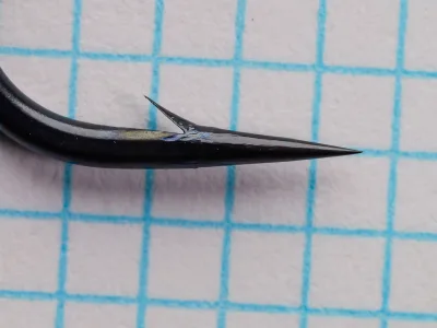 Tiemco TMC 7999 Hook Point Size 2/0 — side profile showing hollow point — barb and taper detail on grid