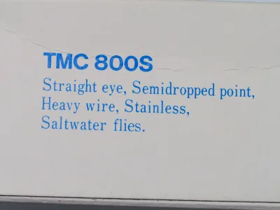 Tiemco TMC 800S package side text — specification description reading 'Straight eye, Semidropped point, Heavy wire, Stainless, Saltwater flies'