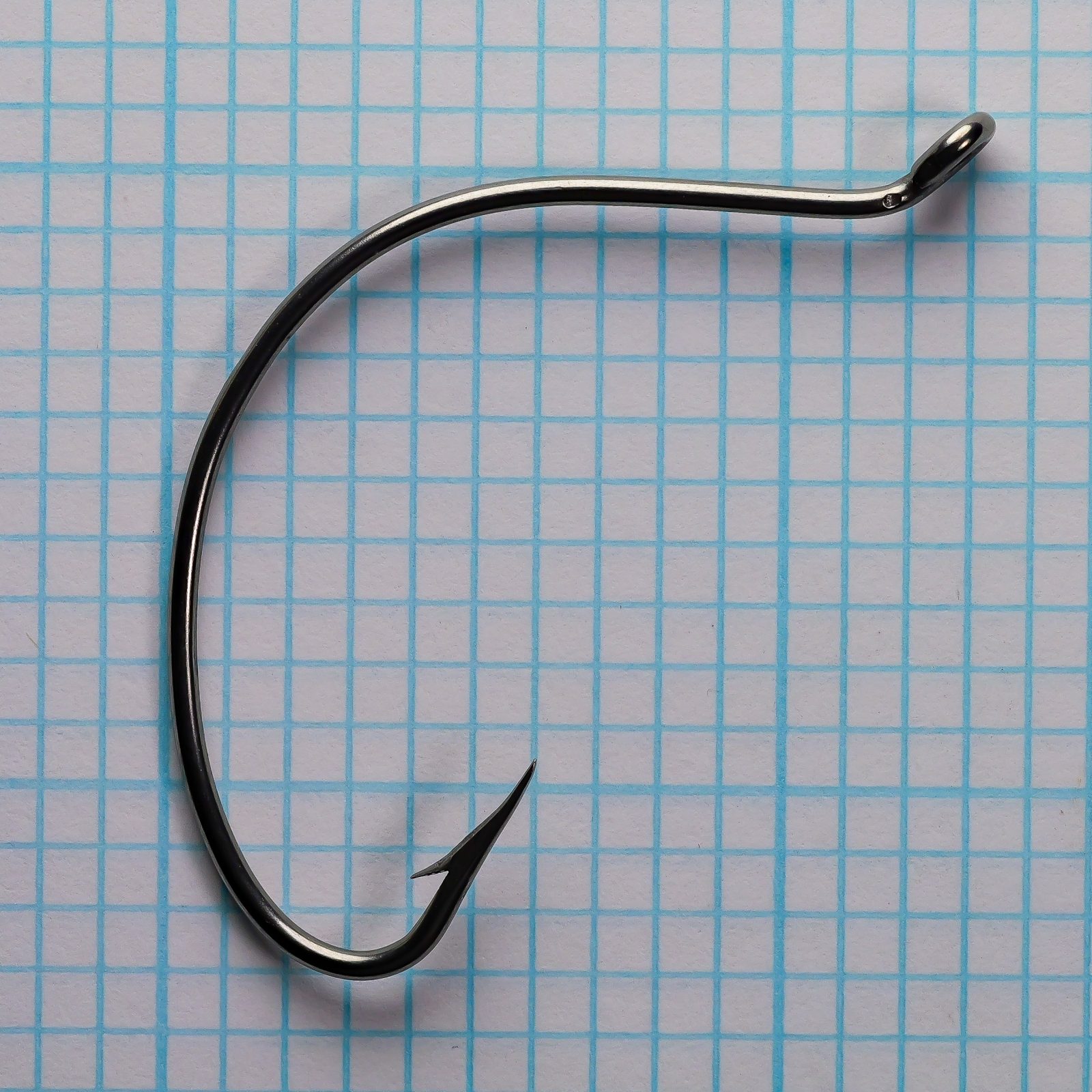 Mustad 37160S Hook — profile view showing Sproat bend and superior point geometry — size 3/0 — polished stainless steel finish — on measurement grid