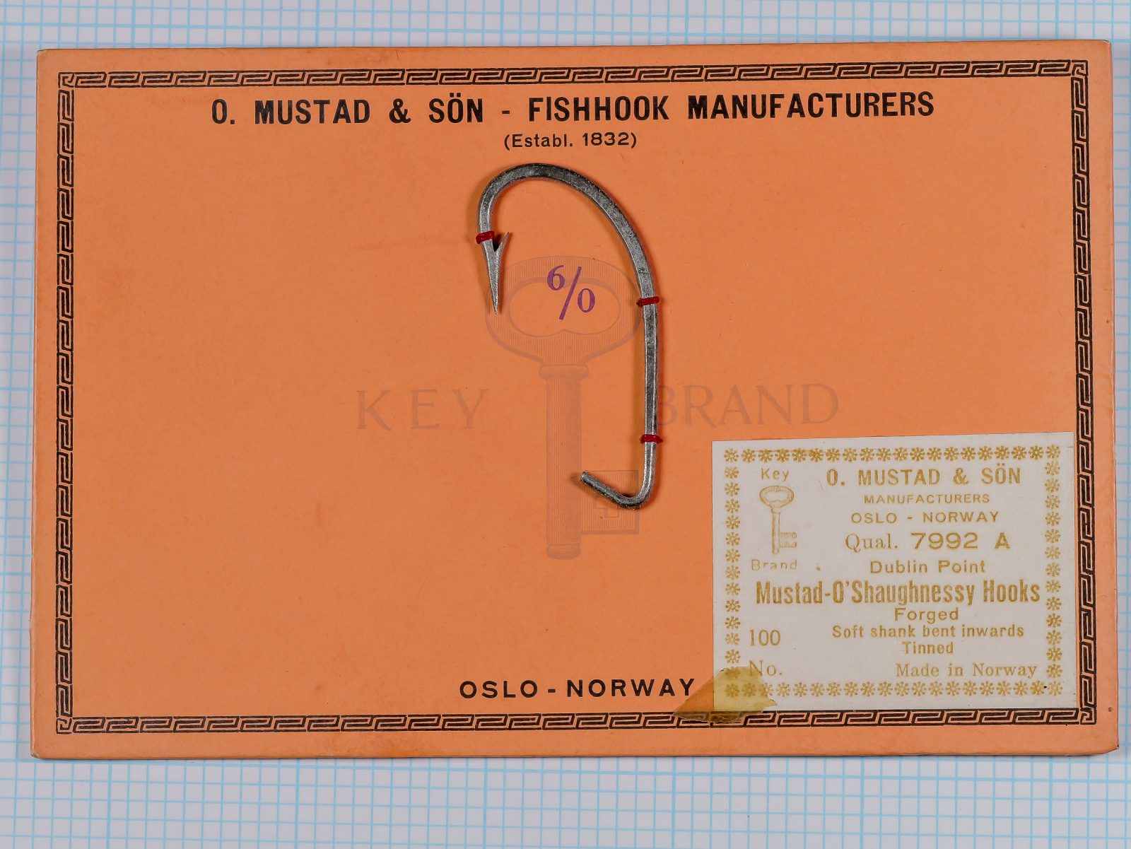 Mustad 7992-A sales card — full front view — orange background with size marking and tie-ribbons