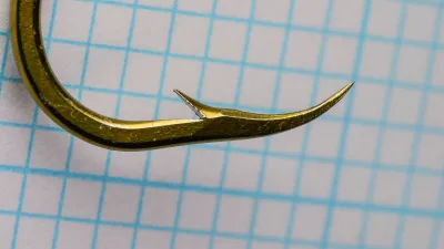 Mustad 92641-BR Hook Point Detail — bronzed hook photographed on measurement grid showing point geometry, barb angle, superior-point profile at high magnification, size 5/0