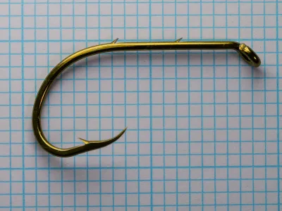 Mustad 92641-BR Complete Hook Profile — full hook showing turned-down ball eye, long shank with two slices, reversed beak bend, and superior point, size 5/0, bronzed finish, on measurement grid