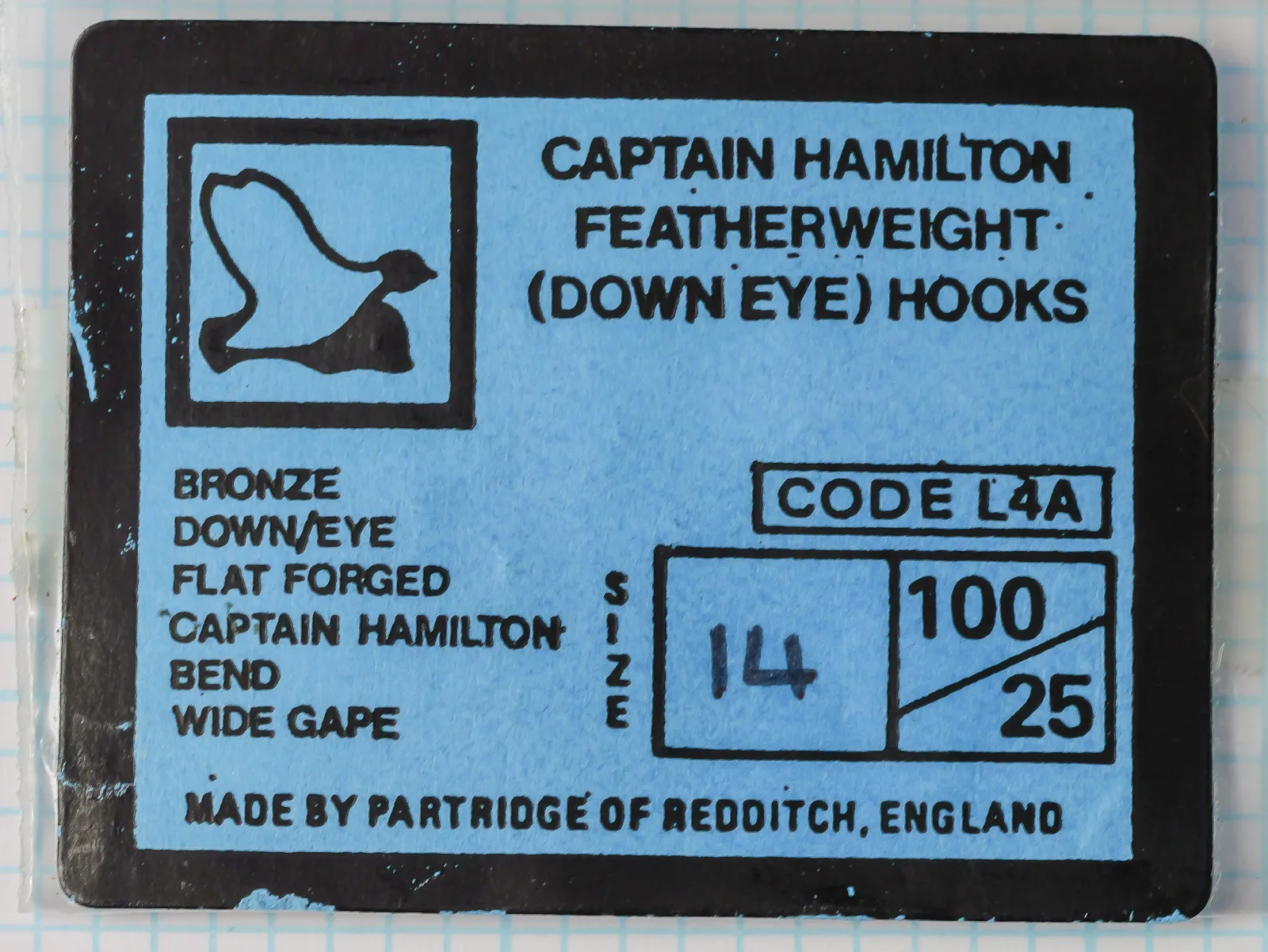 Blue label with a black border on a Partridge L4A packet, size 14 written by hand, behind clear plastic film.
