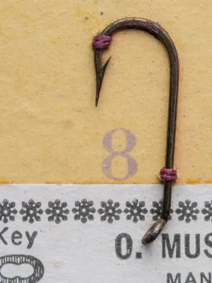 Mustad 77800 size 8 hook specimen — side profile showing ball eye, sproat bend, bronzed finish — on measurement grid