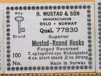 Mustad Superior Round Hooks 77830 — packaging label detail showing specifications, model code, and manufacturer information — letterpress printing