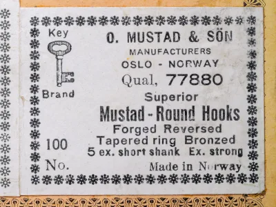 Mustad 77880 quality label detail showing specification text, key logo, Oslo-Norway manufacturing attribution, and 100-hook quantity notation
