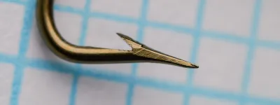 Mustad 199 B reversed beak hook — side profile showing full hook geometry — size 6 (No. 6) — straight ball eye and bronzed finish — on 1/10-inch measurement grid