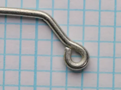 Mustad O'Shaughnessy size 2/0 hook — eye detail showing cross-eye jig orientation at 60-90 degree angle to shank — tinned finish