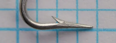 Mustad-Pacific 3498 D size 10 hook—side profile showing Carlisle bend depth, extra-heavy round wire, tinned finish, Superior Point taper, barb position and angle, photographed on measurement grid