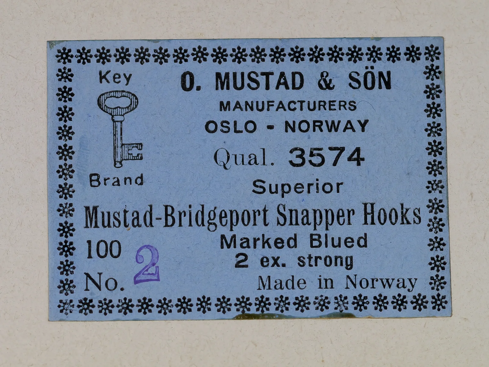Mustad 3574 Bridgeport Snapper box lid — printed specifications and manufacturer information — showing Key Brand logo, Oslo origin, and blued finish designation