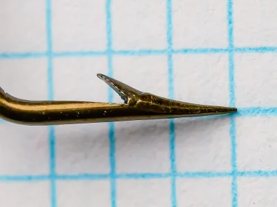 Mustad 3871 hook point and barb detail, bronzed finish, side profile