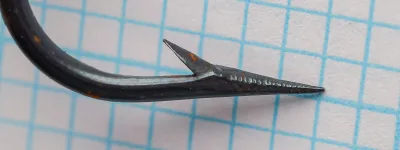 Mustad 3995 hook profile view showing round Kendal bend, hollow point, and barb