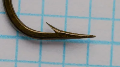 Mustad 57552 Hameçons Ronds size No. 1 — side profile showing bend shape and hollow point — bronzed finish on grid