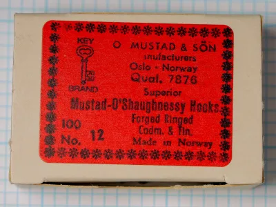 Mustad 7876 O'Shaughnessy box — original packaging lid with red printed label — showing manufacturer information and hook specifications