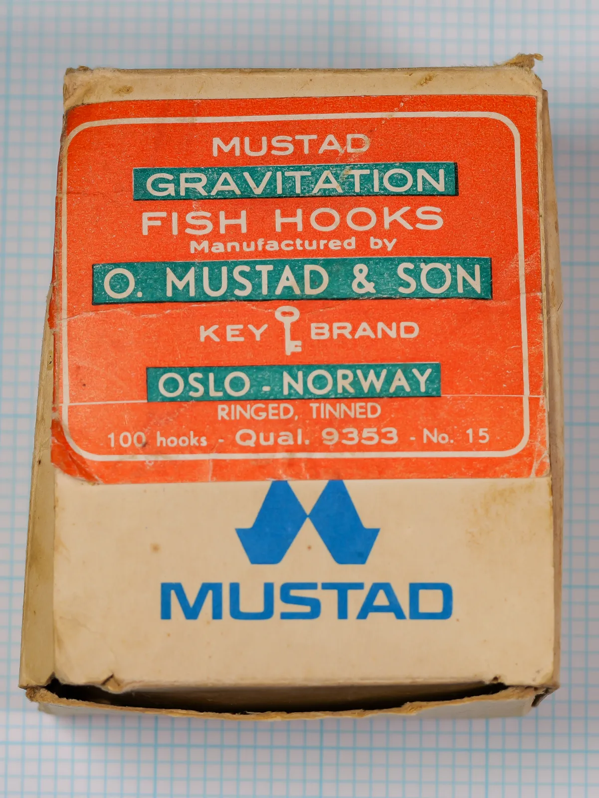 Mustad Gravitation model 9353 — manufacturer box, front panel, showing orange label with white and teal typography — specifications for 100 hooks, size 15, tinned finish