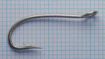 Mustad Gravitation size 15 — overall hook profile from above, showing shank alignment and gap width — tinned bright-silver finish