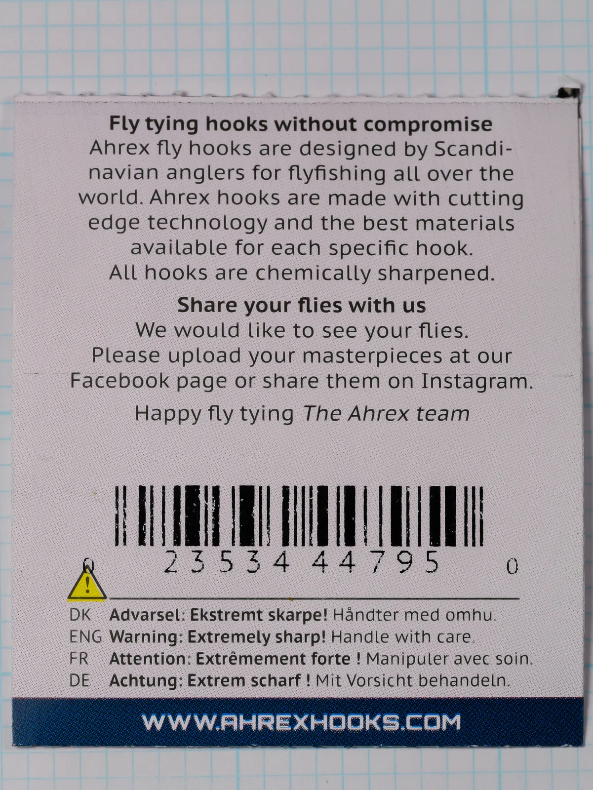 Back of an Ahrex FW502 size 12 packet showing the maker's text, a barcode and a four-language sharpness warning.