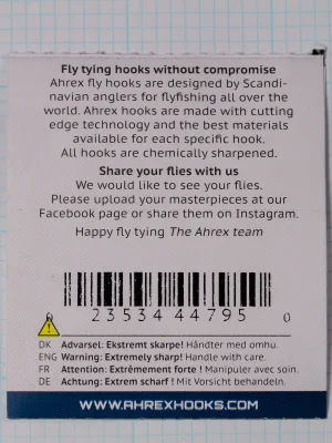 Back of an Ahrex FW502 size 12 packet showing the maker's text, a barcode and a four-language sharpness warning.