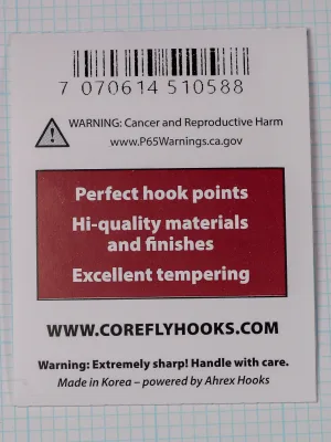 Back of a white card with a barcode, a warning notice and triangle icon, a maroon panel of white text, the Core web address and a made-in line.