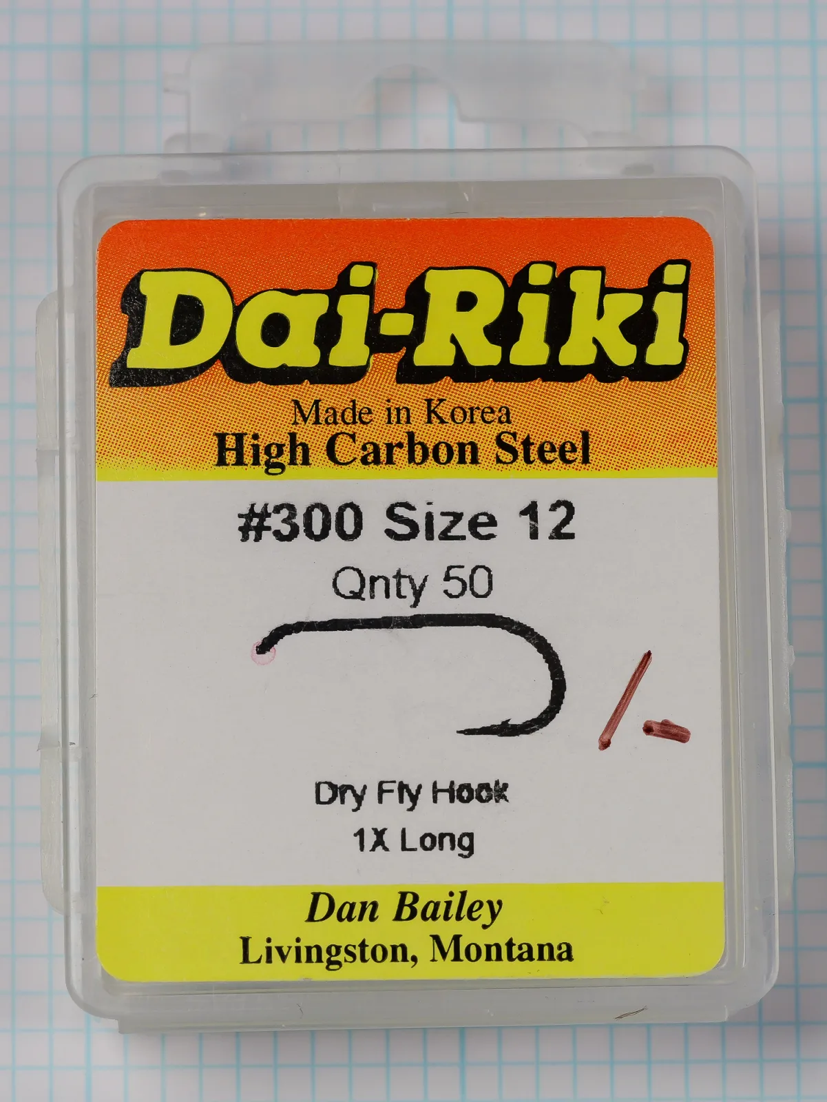 Front of a clear plastic box of Dai-Riki 300 size 12 hooks with an orange, white and yellow label and a printed hook drawing.