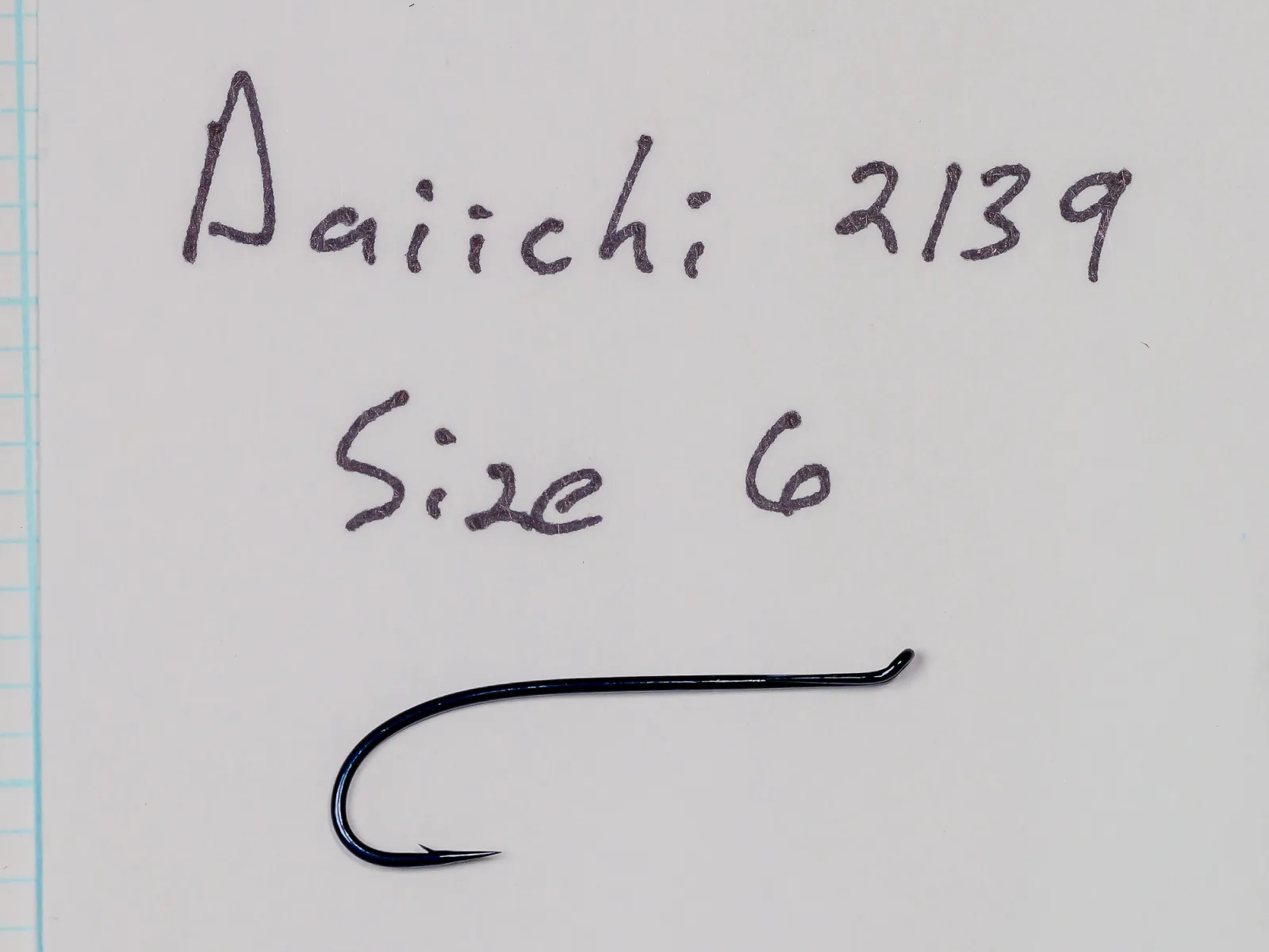 Handwritten card reading Daiichi 2139, Size 6, above a blue-black fish hook.