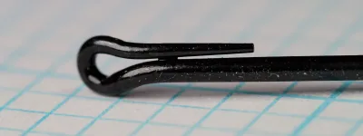 Macro view of a black looped hook eye, the tapered return wire lying along the top of the shank.