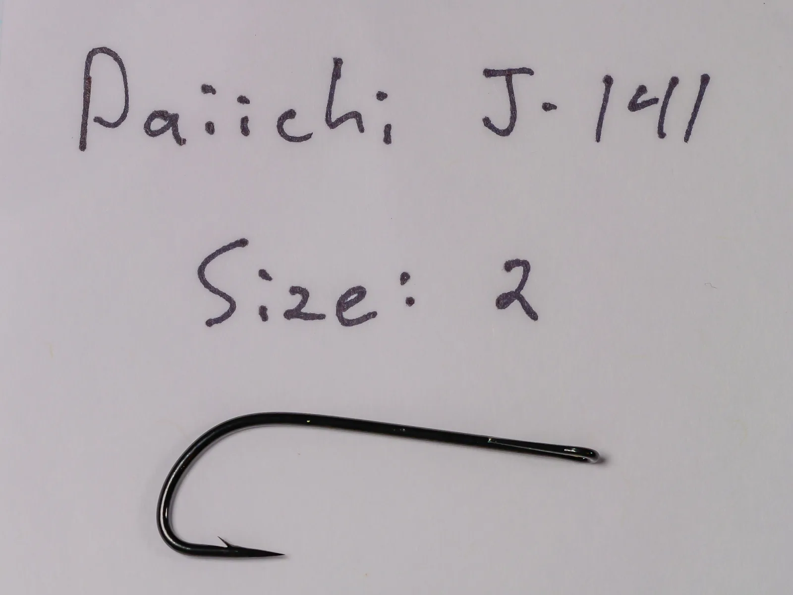 Handwritten note reading "Daiichi J·1411" and "Size: 2" above a loose black hook on plain paper.