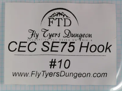 White printed label with an arched mountain-peak logo over FTD, a script Fly Tyers Dungeon wordmark, the line CEC SE75 Hook, the size #10 and the web address www.FlyTyersDungeon.com.