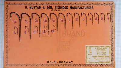 Mustad sales card with 18 blind-end Limerick hooks sewn on with red thread in two rows, each size from 6/0 to 12 stamped in purple beside it, and a gold-printed Qual. 3661 label at lower right.