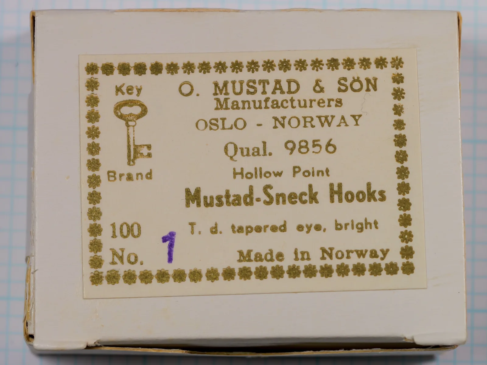 Mustad box lid with a gold-printed Key Brand label reading Qual. 9856, Mustad-Sneck Hooks, with size 1 written in purple after No.