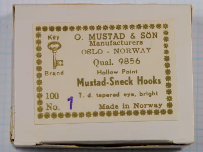 Mustad box lid with a gold-printed Key Brand label reading Qual. 9856, Mustad-Sneck Hooks, with size 1 written in purple after No.