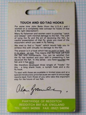 Back of the green Partridge Touch and Go Tag Hooks card, with printed text about the design, a printed signature and the Redditch address band.