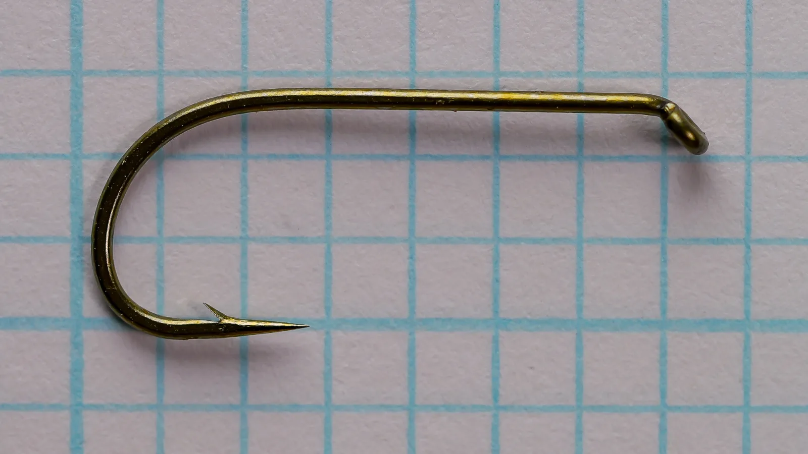 Tiemco 100 size 8 bronzed dry fly hook displayed on grid, side view showing round Kendal bend and down eye