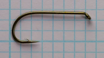 Tiemco 100 size 8 bronzed dry fly hook displayed on grid, side view showing round Kendal bend and down eye